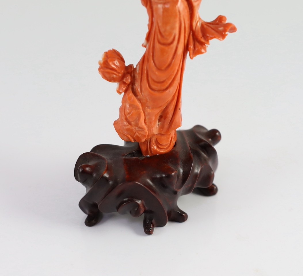 A Chinese carved coral figure of a flower fairy, 20th century, the carving 19cm high and 119g, wood stand